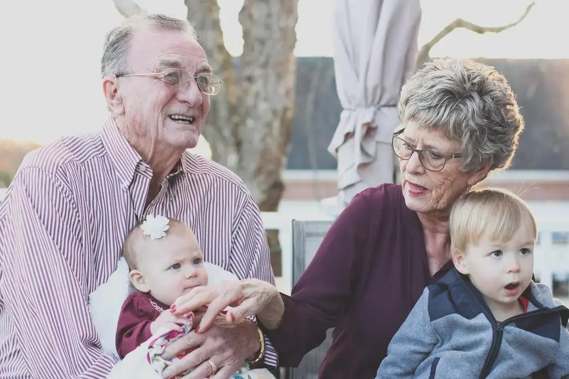 An elderly couple happy knowing that theirs and their grandchildren's dermatological issues are covered.