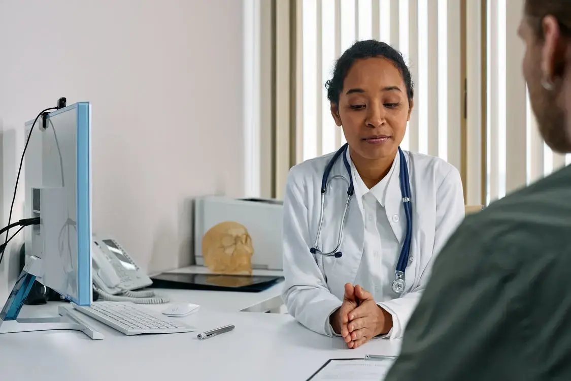 A doctor explaining to a patient which dermatology issues are covered by Medicare.