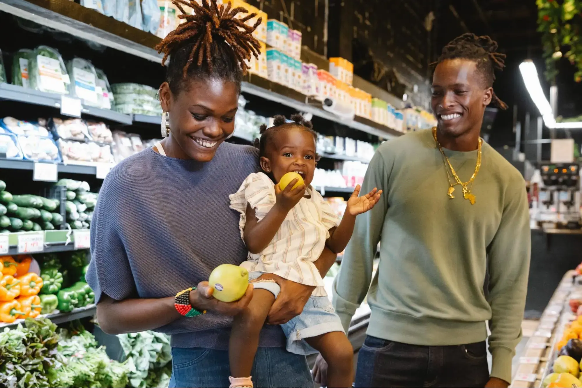 Happy couple and their young child buying groceries at the supermarket.