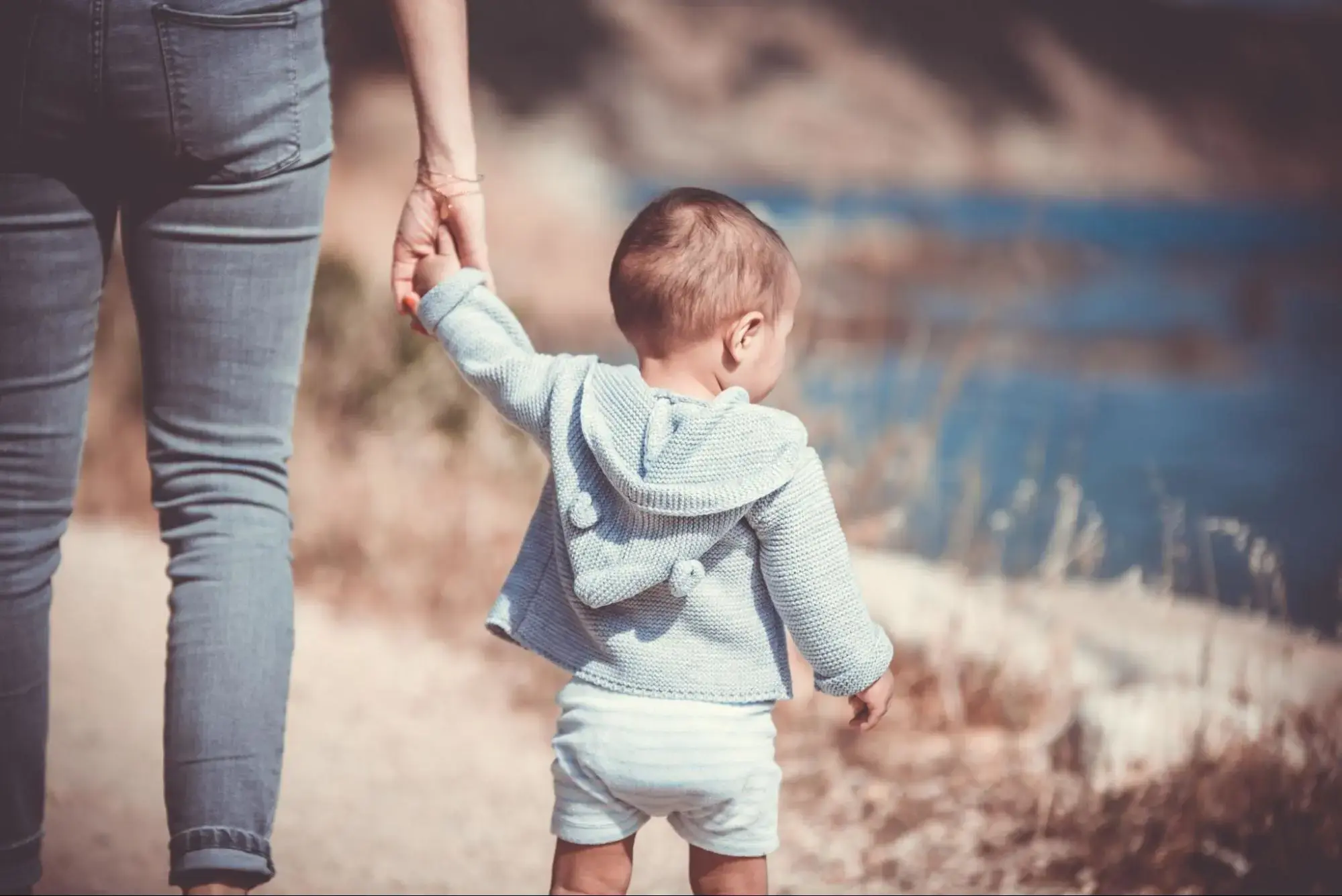 A mother holding her Childs hand.