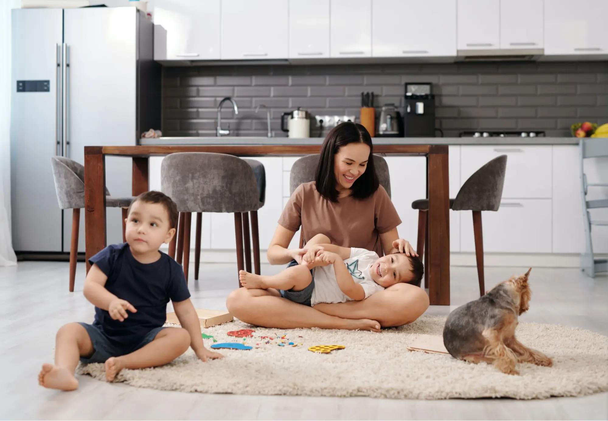 A mother playing with her children who are covered by Life Insurance.