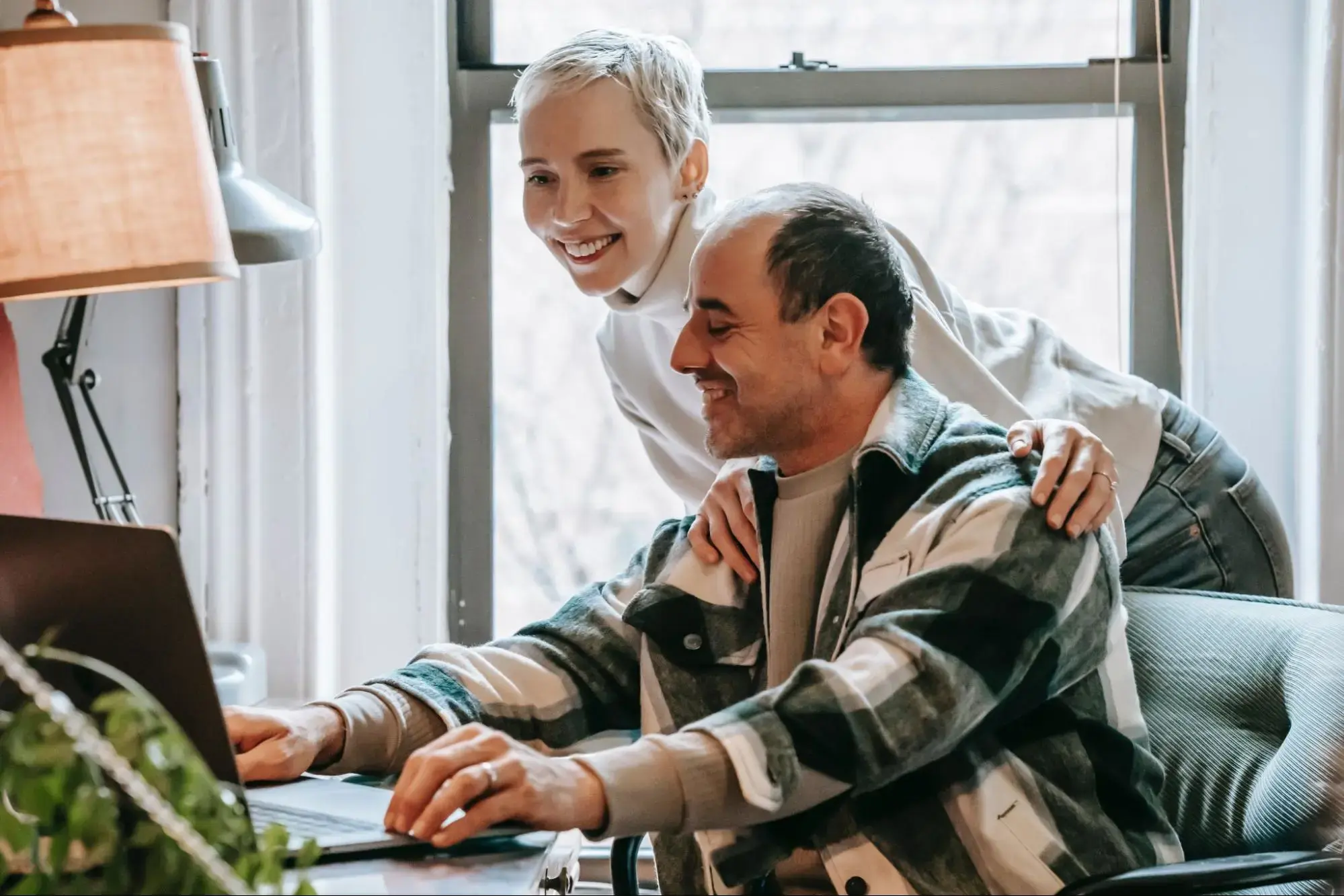 Couple around a computer picking a supplemental insurance plan.