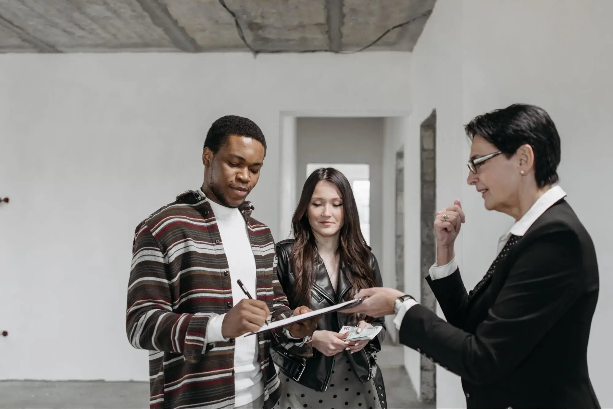 Happy couple with their insurance agent signing a level term life insurance policy.