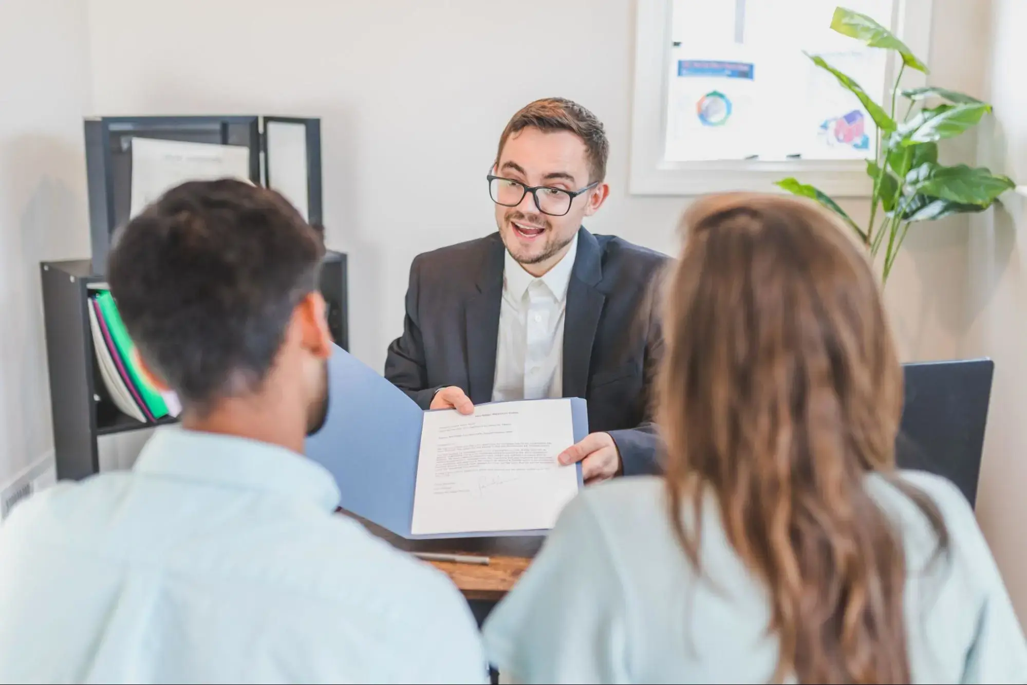 A couple at an insurance agent consultation learning about level term life insurance.